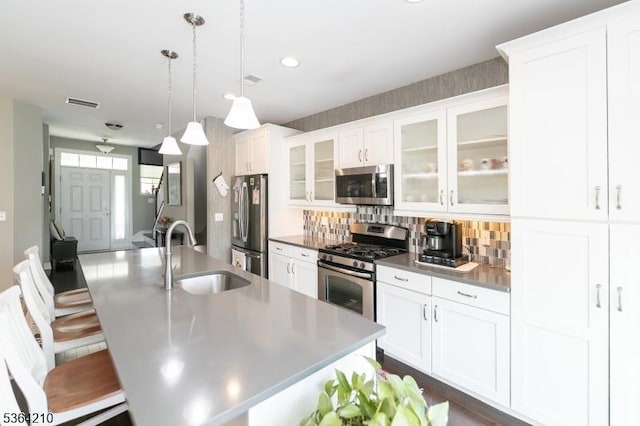 3 Indigo Rd, Allamuchy Twp, NJ 07840 - kitchen featuring appliances with stainless steel finishes, a center island with sink, backsplash, a breakfast bar area, and white cabinets