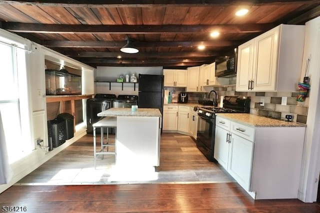 214 Franklin Ave, Seaside Heights Boro, NJ 08751 - kitchen with black appliances, separate washer and dryer, a wood ceiling with exposed beams, a kitchen bar, and a center island