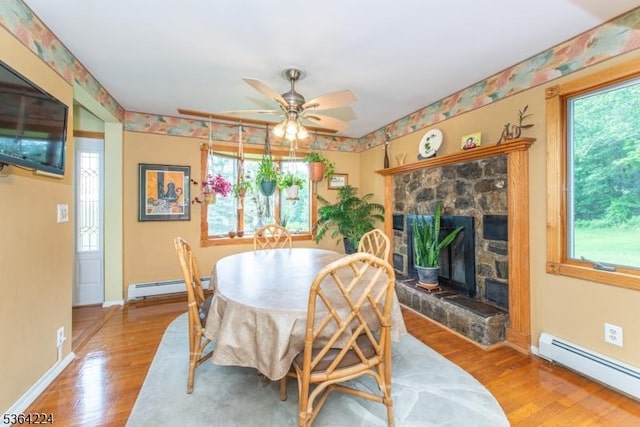 25 Mordaunt Rd, Vernon Twp, NJ 07462 - dining room with baseboard heating, wood finished floors, a stone fireplace, and ceiling fan
