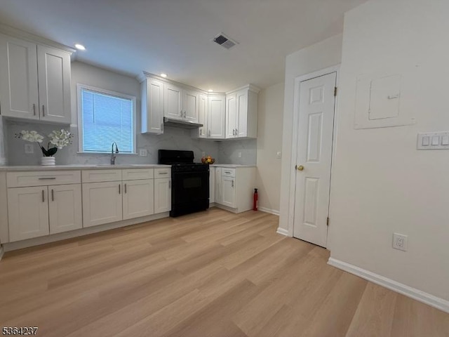 33 Fisher Ave, Bound Brook Boro, NJ 08805 - kitchen with black range with gas cooktop, light wood-type flooring, white cabinets, light countertops, and tasteful backsplash