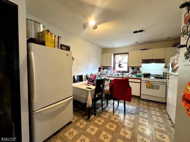 33 Fisher Ave, Bound Brook Boro, NJ 08805 - kitchen with white appliances, under cabinet range hood, light floors, and white cabinets