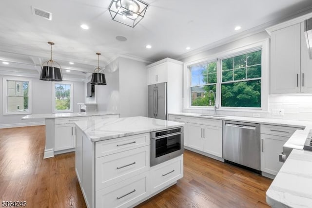 4 Hanover Rd Unit 1, Florham Park Boro, NJ 07932 - kitchen with stainless steel appliances, crown molding, a center island, light stone counters, and dark wood finished floors