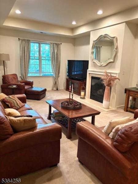 28 Ridgeview Ln, Mount Arlington Boro, NJ 07856 - living room with a tray ceiling, light carpet, a fireplace, and recessed lighting