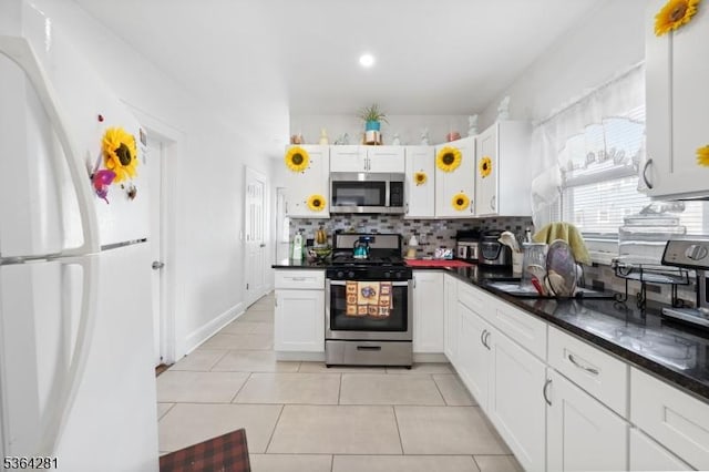 684 Harrison St, Rahway City, NJ 07065 - kitchen featuring appliances with stainless steel finishes, decorative backsplash, dark countertops, white cabinetry, and light tile patterned flooring