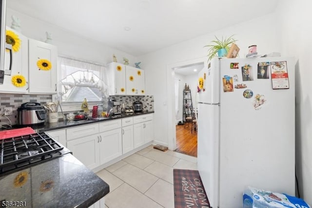 684 Harrison St, Rahway City, NJ 07065 - kitchen featuring freestanding refrigerator, white cabinetry, backsplash, and light tile patterned floors