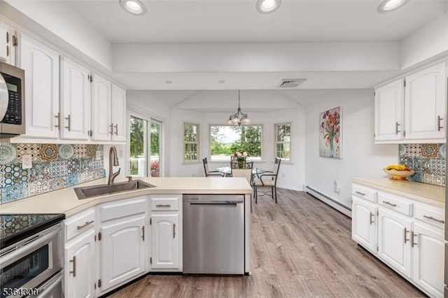 1 Warwick Dr, Washington Twp, NJ 07853 - kitchen with appliances with stainless steel finishes, a baseboard heating unit, a peninsula, plenty of natural light, and recessed lighting