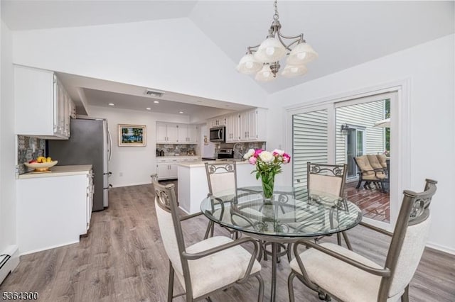 1 Warwick Dr, Washington Twp, NJ 07853 - dining space featuring a chandelier, light wood-style flooring, a baseboard radiator, and high vaulted ceiling
