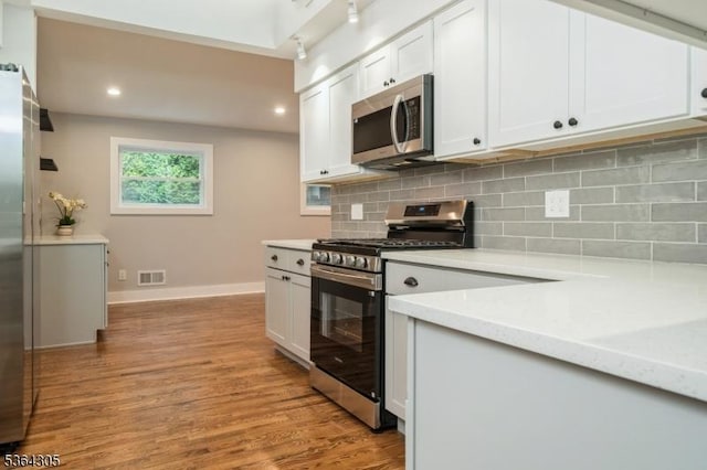 9 Somerset Pl, West Milford Twp, NJ 07480 - kitchen with stainless steel appliances, light countertops, light wood-style flooring, backsplash, and white cabinetry