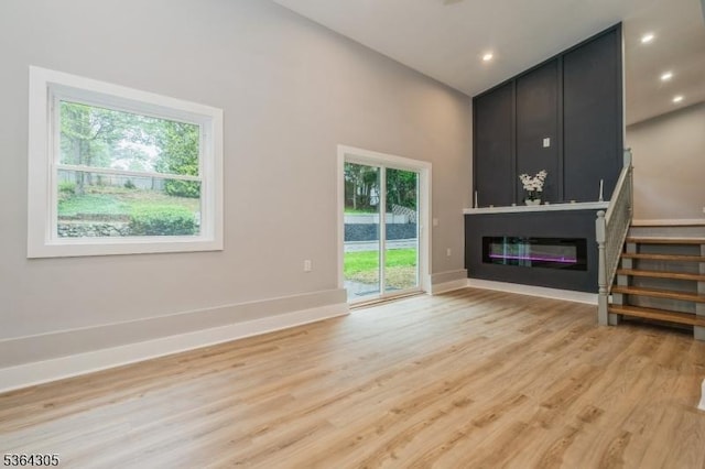 9 Somerset Pl, West Milford Twp, NJ 07480 - unfurnished living room with a large fireplace, light wood-style flooring, stairs, and recessed lighting