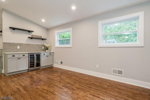 9 Somerset Pl, West Milford Twp, NJ 07480 - indoor dry bar with beverage cooler, decorative backsplash, dark wood-type flooring, recessed lighting, and lofted ceiling