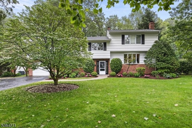 2242 Shawnee Path, Scotch Plains Twp, NJ 07076 - split level home with brick siding, a chimney, driveway, a front lawn, and a garage