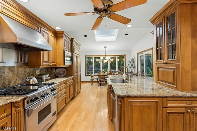 2242 Shawnee Path, Scotch Plains Twp, NJ 07076 - kitchen with appliances with stainless steel finishes, wall chimney range hood, brown cabinets, ceiling fan, and light wood-style flooring