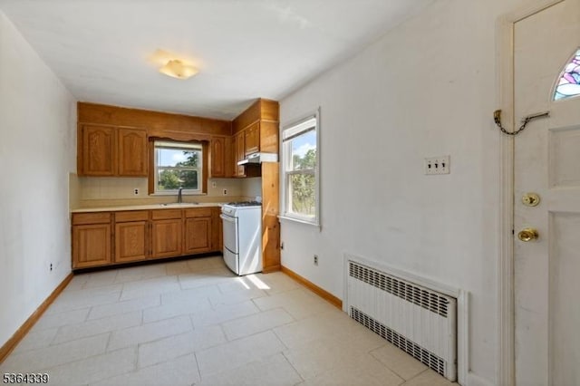 87 S Ridgedale Ave, East Hanover Twp, NJ 07936 - kitchen with radiator heating unit, white gas range, light countertops, under cabinet range hood, and brown cabinets