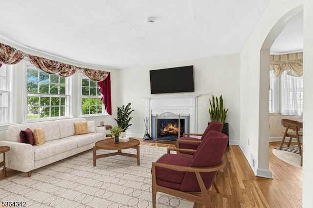 203 Beech St, Cranford Twp, NJ 07016 - living room with wood finished floors, arched walkways, and a lit fireplace