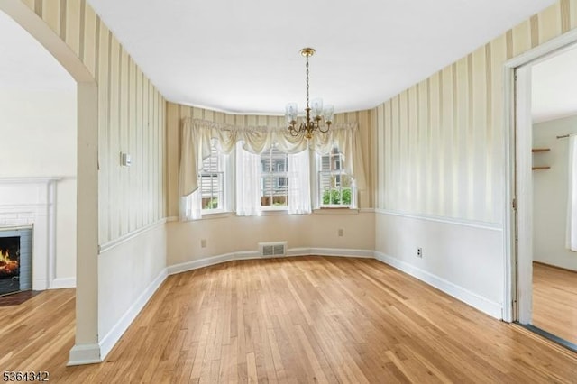 203 Beech St, Cranford Twp, NJ 07016 - unfurnished dining area featuring wood finished floors, wallpapered walls, a chandelier, and a fireplace with flush hearth