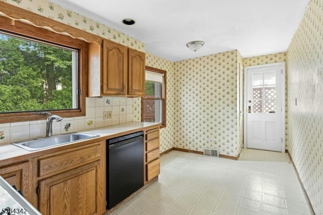 203 Beech St, Cranford Twp, NJ 07016 - kitchen with black dishwasher, wallpapered walls, healthy amount of natural light, light countertops, and brown cabinetry