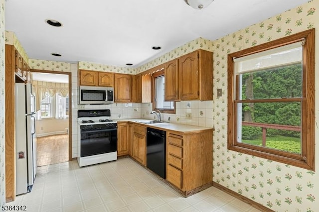 203 Beech St, Cranford Twp, NJ 07016 - kitchen featuring white gas stove, black dishwasher, stainless steel microwave, freestanding refrigerator, and wallpapered walls