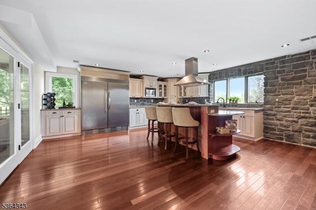 231 Woods Rd, Hillsborough Twp, NJ 08844 - kitchen with stainless steel appliances, island range hood, a kitchen breakfast bar, glass insert cabinets, and cream cabinetry