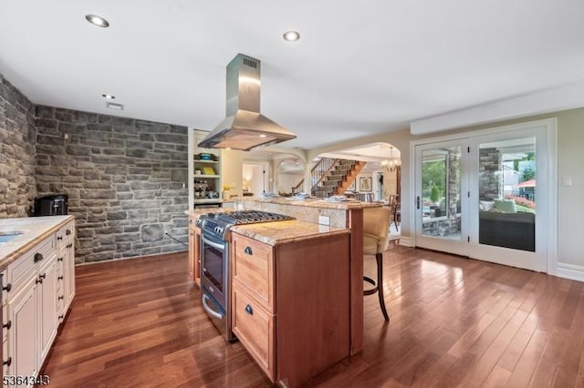 231 Woods Rd, Hillsborough Twp, NJ 08844 - kitchen featuring stainless steel range with gas stovetop, island range hood, a breakfast bar area, dark wood-style flooring, and arched walkways