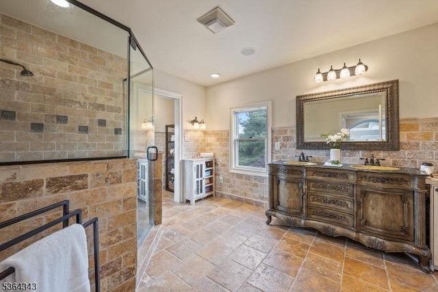 231 Woods Rd, Hillsborough Twp, NJ 08844 - bathroom featuring double vanity, a shower stall, stone tile floors, tile walls, and a fireplace