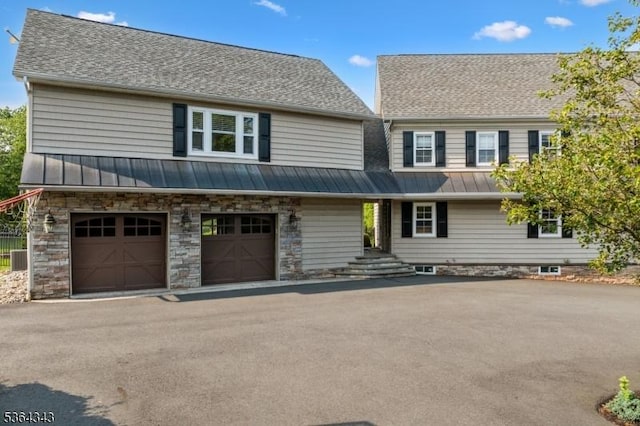231 Woods Rd, Hillsborough Twp, NJ 08844 - view of front facade with a standing seam roof, driveway, a garage, a metal roof, and roof with shingles