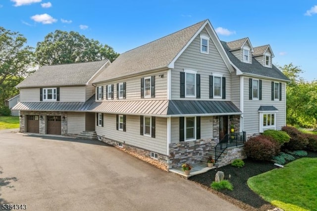 231 Woods Rd, Hillsborough Twp, NJ 08844 - view of property with a standing seam roof, driveway, a metal roof, covered porch, and an attached garage