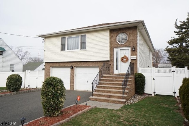 44 Joseph St, Clark Twp, NJ 07066 - bi-level home with a gate, brick siding, an attached garage, driveway, and entry steps