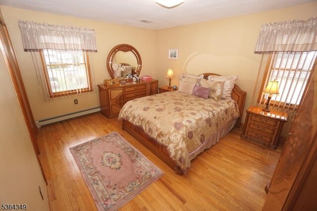 44 Joseph St, Clark Twp, NJ 07066 - bedroom featuring baseboard heating, multiple windows, and light wood-style flooring