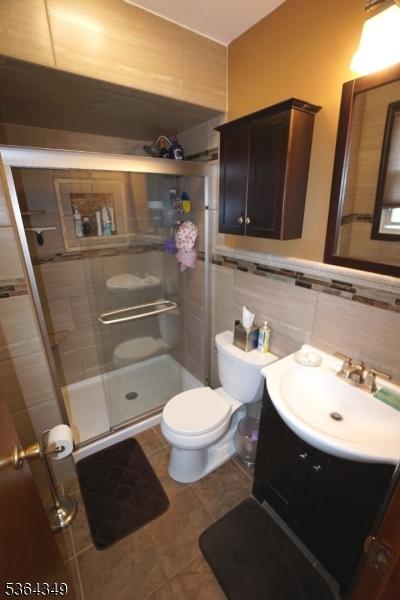 44 Joseph St, Clark Twp, NJ 07066 - full bathroom featuring vanity, a stall shower, tile patterned floors, and tile walls