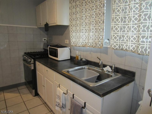 7 Brunswick Ave, Union Twp, NJ 07088 - kitchen featuring white microwave, gas range, tile walls, white cabinetry, and dark countertops