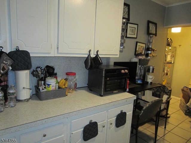 7 Brunswick Ave, Union Twp, NJ 07088 - kitchen with white cabinetry, crown molding, light tile patterned floors, light countertops, and refrigerator