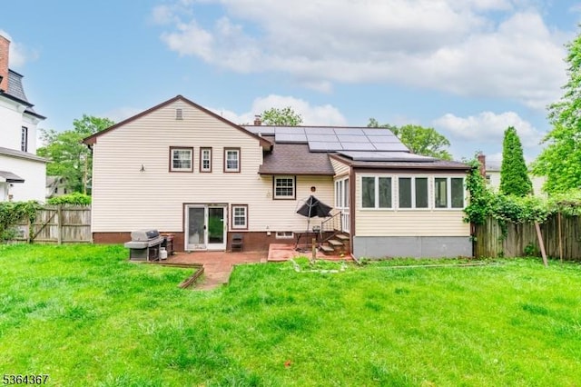 1126-1200 Grant Ave, Plainfield City, NJ 07060 - back of property with roof mounted solar panels, a patio, a fenced backyard, and roof with shingles