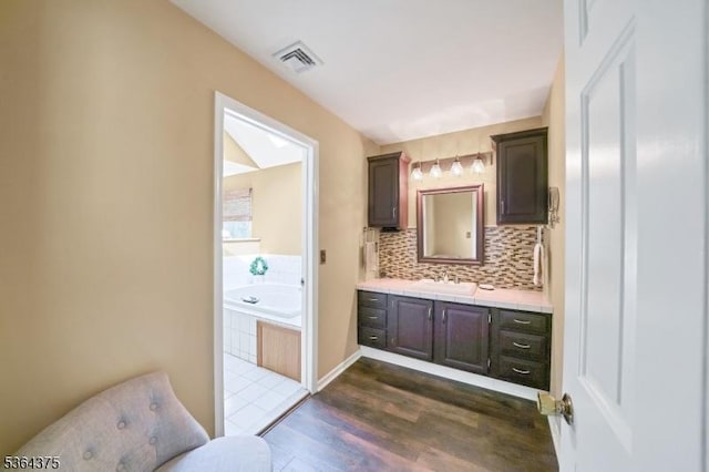 125 Drakestown Rd, Washington Twp, NJ 07853 - full bath with vanity, a garden tub, wood finished floors, and decorative backsplash