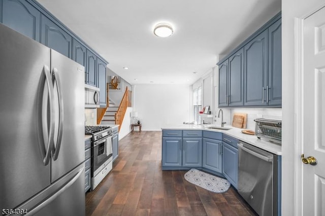 156 Arrowgate Dr, Randolph Twp, NJ 07869 - kitchen with appliances with stainless steel finishes, a peninsula, blue cabinetry, light countertops, and dark wood finished floors