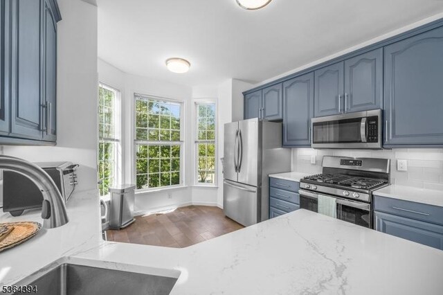 156 Arrowgate Dr, Randolph Twp, NJ 07869 - kitchen featuring appliances with stainless steel finishes, dark wood-style floors, blue cabinetry, tasteful backsplash, and light stone countertops