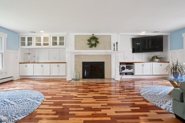 18 Forest Trl, Bernards Twp, NJ 07920 - living room with a decorative wall, light wood-type flooring, a wainscoted wall, a fireplace, and a baseboard radiator