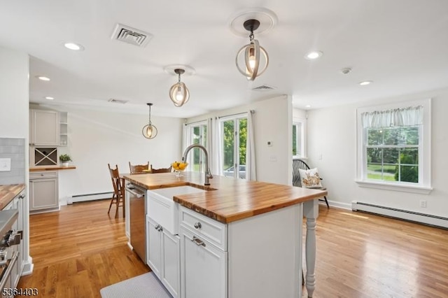 18 Forest Trl, Bernards Twp, NJ 07920 - kitchen featuring wooden counters, stainless steel dishwasher, baseboard heating, light wood finished floors, and hanging light fixtures