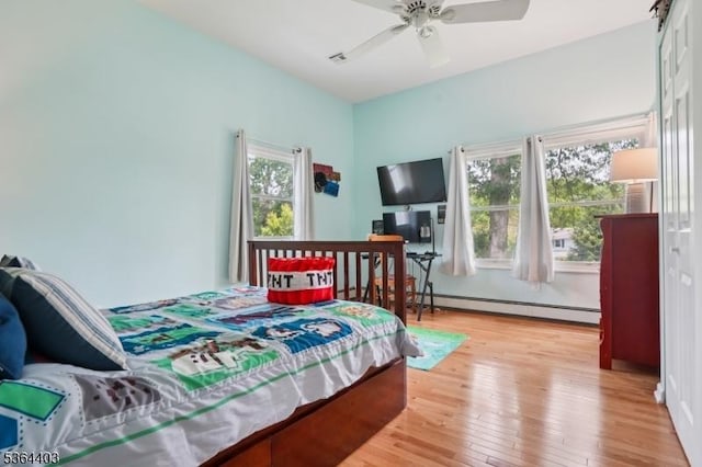 18 Forest Trl, Bernards Twp, NJ 07920 - bedroom featuring a baseboard heating unit, light wood-style floors, and ceiling fan