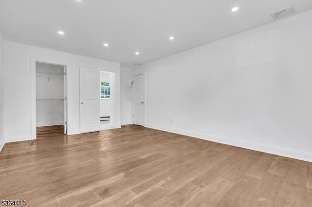 71 Tiffany Dr, East Hanover Twp, NJ 07936 - unfurnished bedroom featuring a spacious closet, light wood-style floors, recessed lighting, and a baseboard radiator
