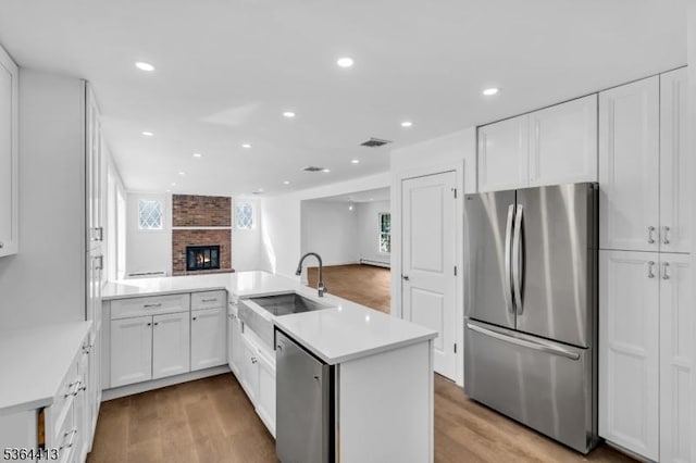 71 Tiffany Dr, East Hanover Twp, NJ 07936 - kitchen featuring stainless steel appliances, a peninsula, plenty of natural light, light wood-style floors, and recessed lighting