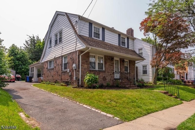 28 Overlook Ter, Maplewood Twp, NJ 07040 - colonial inspired home featuring a chimney, a front yard, stone siding, a gambrel roof, and a shingled roof