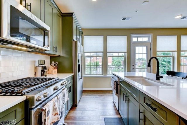 1005 Station Rd, Somerville Boro, NJ 08876 - kitchen featuring appliances with stainless steel finishes, green cabinetry, plenty of natural light, light countertops, and recessed lighting