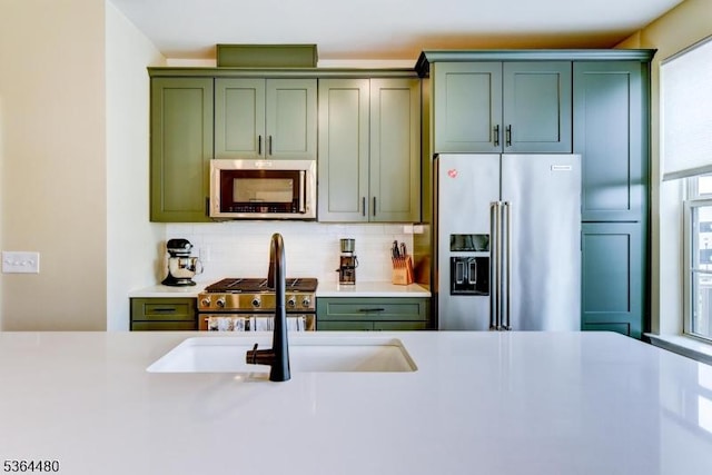1005 Station Rd, Somerville Boro, NJ 08876 - kitchen featuring appliances with stainless steel finishes, green cabinetry, light countertops, and backsplash