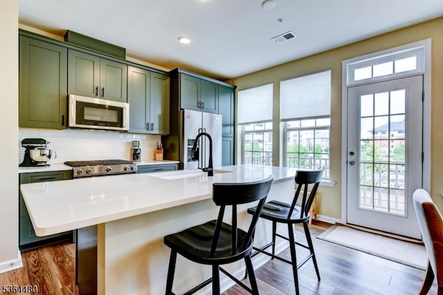 1005 Station Rd, Somerville Boro, NJ 08876 - kitchen with appliances with stainless steel finishes, green cabinets, dark wood-type flooring, light countertops, and tasteful backsplash
