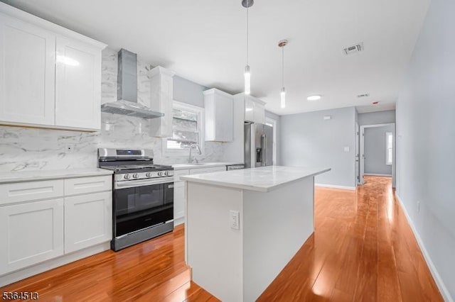 125 Birch St, Bloomfield Twp, NJ 07003 - kitchen with stainless steel appliances, wall chimney exhaust hood, light wood-type flooring, backsplash, and white cabinetry