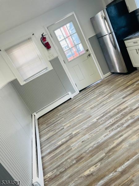 226 N 3rd Ave, Manville Boro, NJ 08835 - kitchen with light wood-style floors, white cabinetry, and freestanding refrigerator