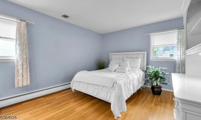 32 Sanford Dr, Randolph Twp, NJ 07869 - bedroom featuring a baseboard heating unit and light wood finished floors