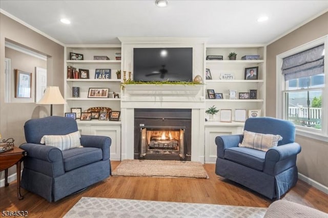 31 Somerville Rd, West Milford Twp, NJ 07421 - living area with a lit fireplace, wood finished floors, built in features, and crown molding