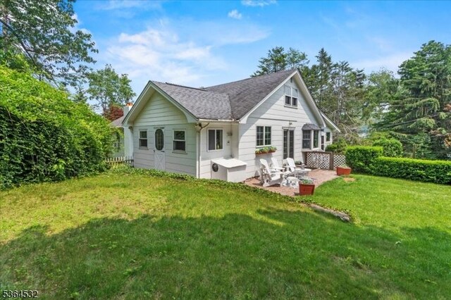 31 Somerville Rd, West Milford Twp, NJ 07421 - back of property featuring a patio, a lawn, and a shingled roof