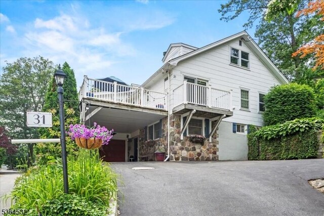 31 Somerville Rd, West Milford Twp, NJ 07421 - back of property with driveway, stone siding, and a balcony
